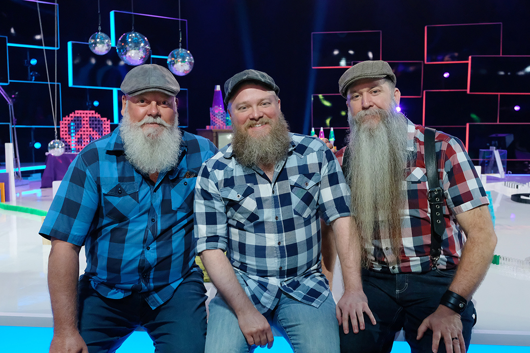 three men with beards and wearing plaid shirts.