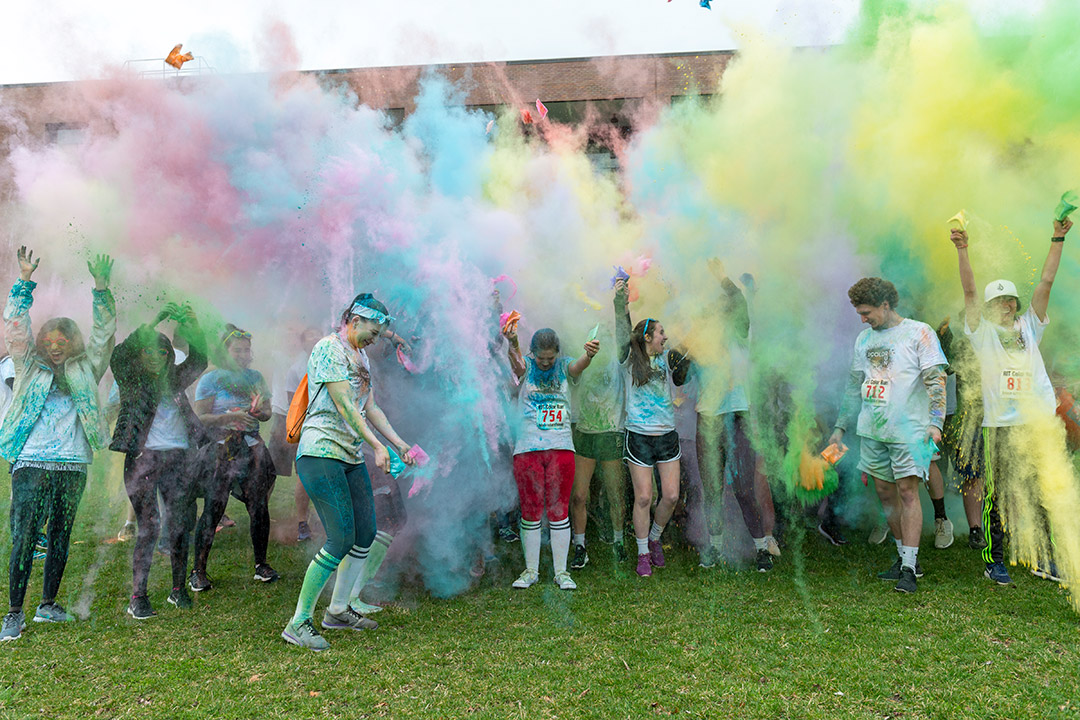 students in a race throwing colored power in the air.