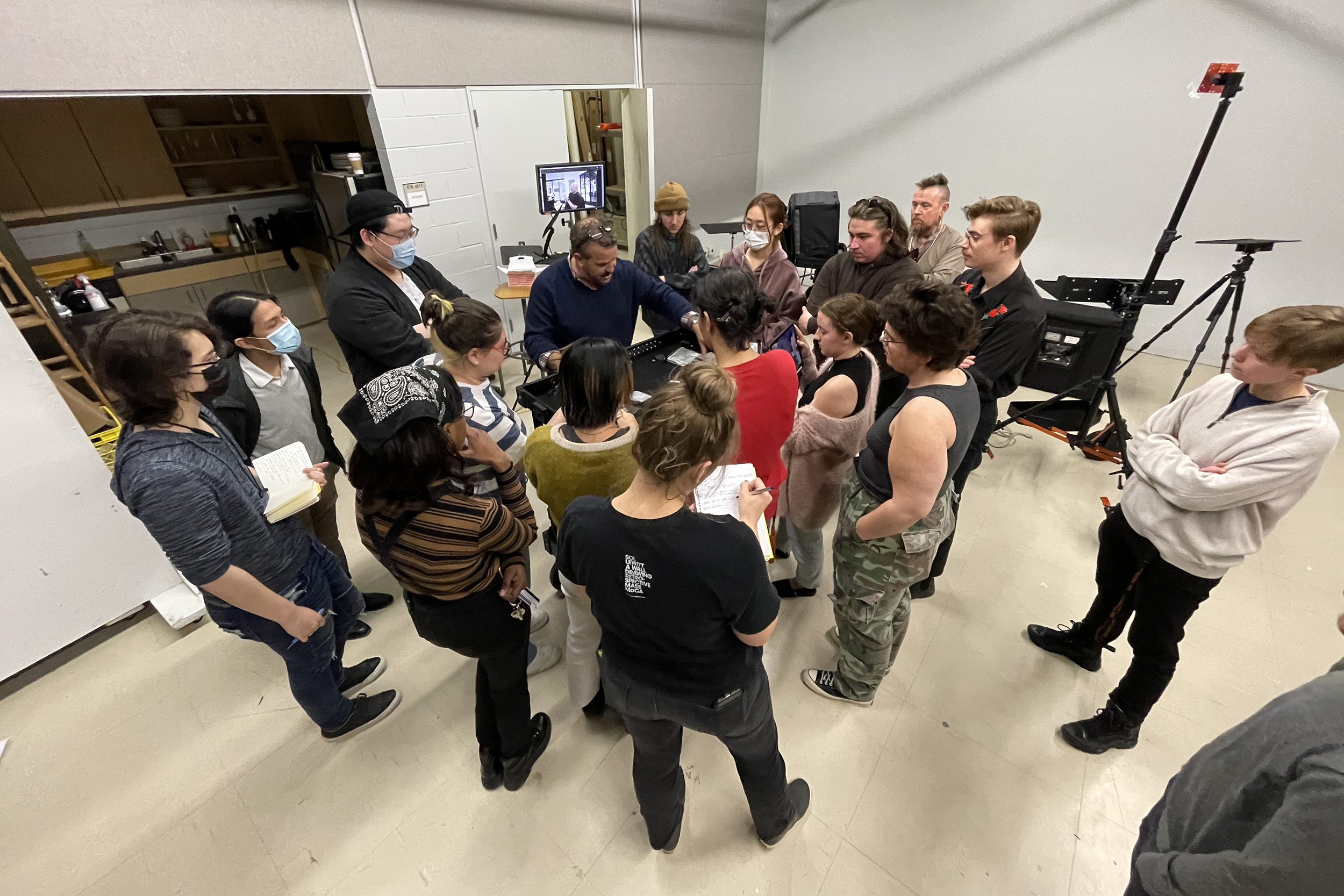 A group of students and instructors look at high-tech studio photography equipment.