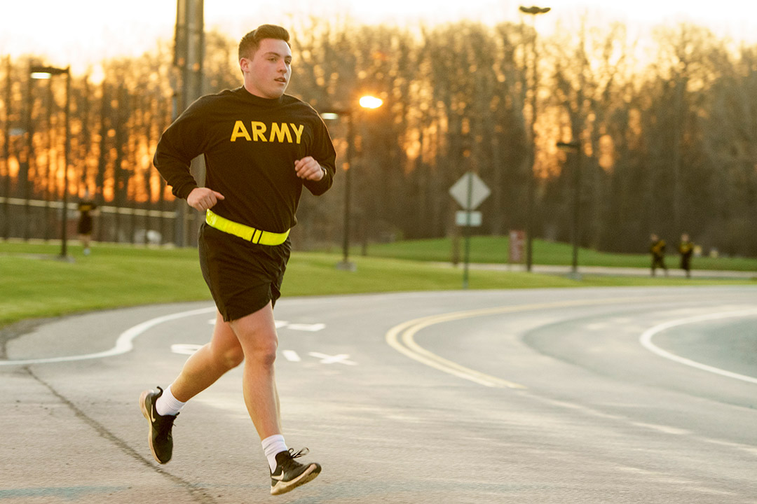 ROTC student running in a road at dusk.