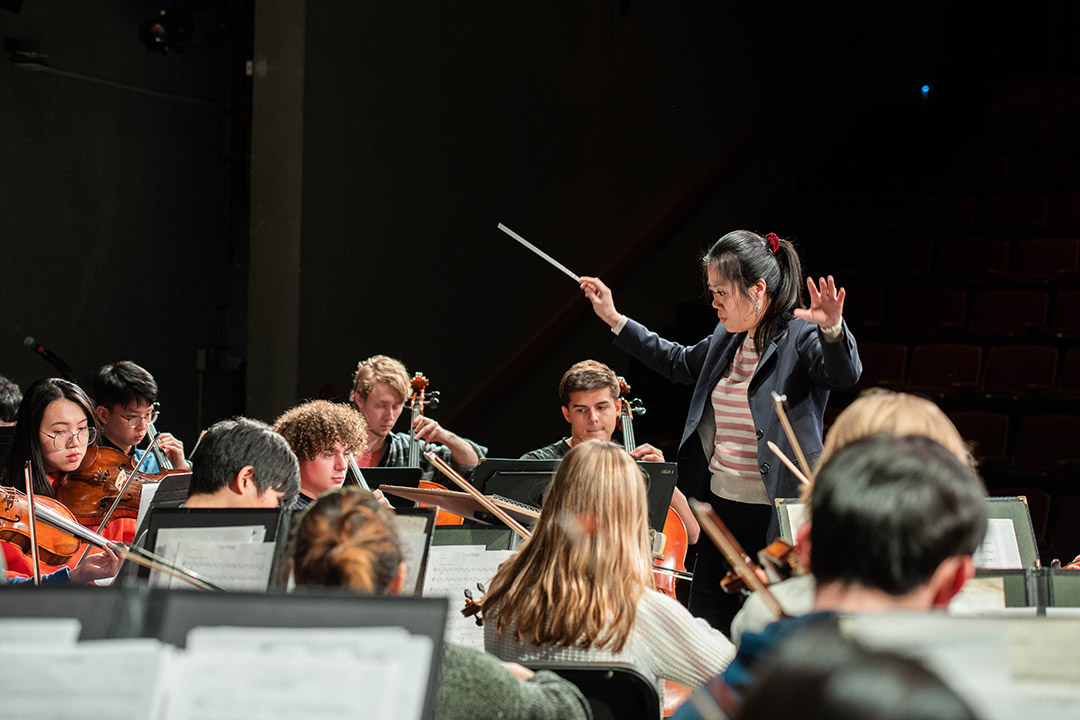 woman conducting an orchestra.