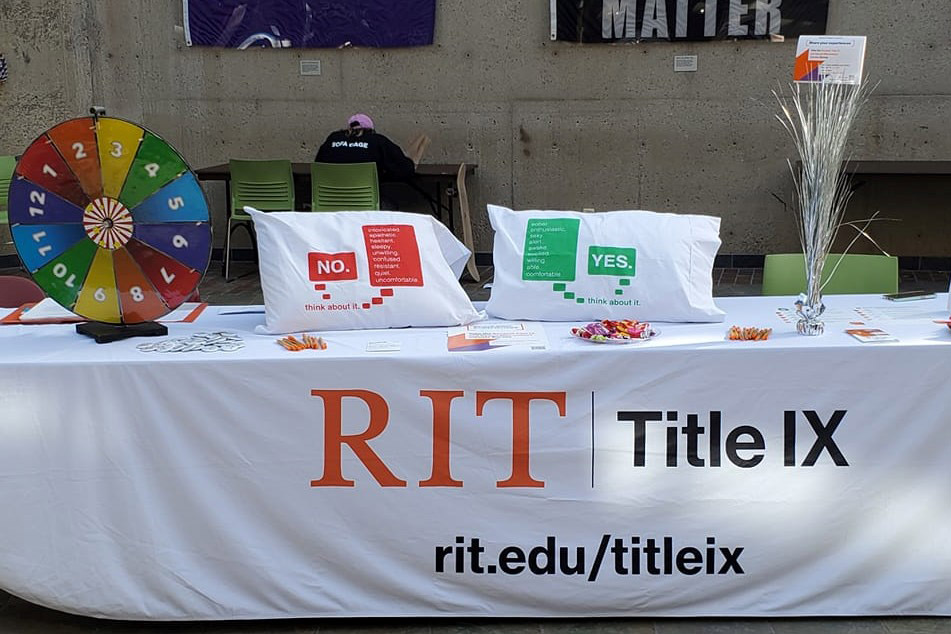 table with games, giveaways, and a banner that reads RIT Title nine.