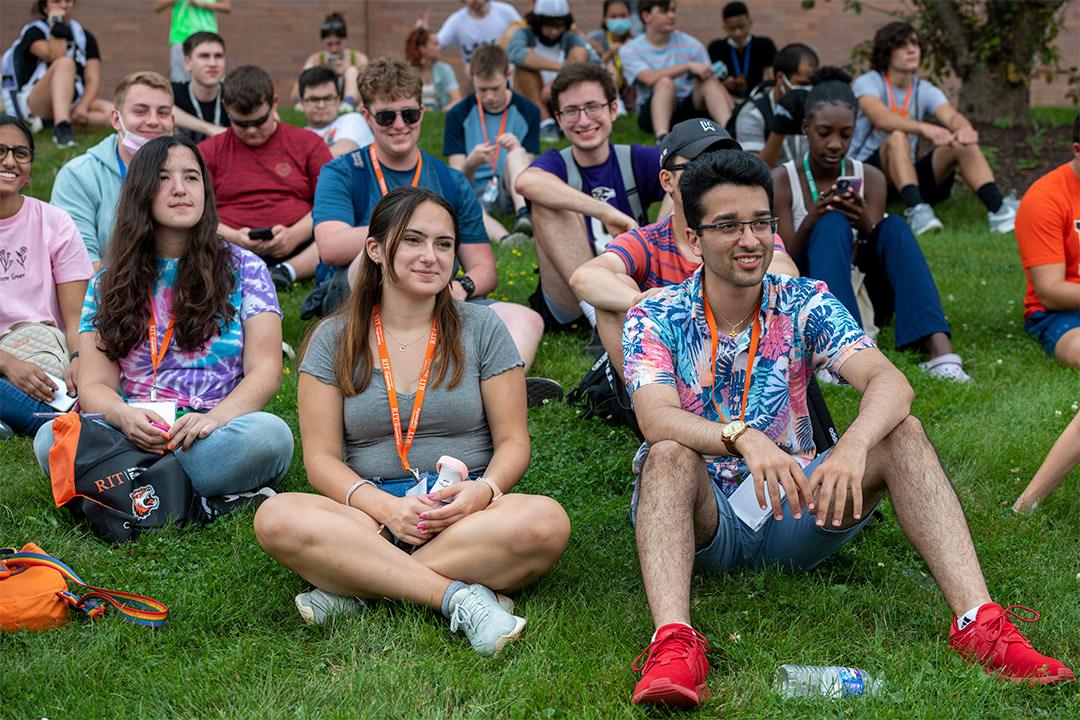 students sitting on lawn.