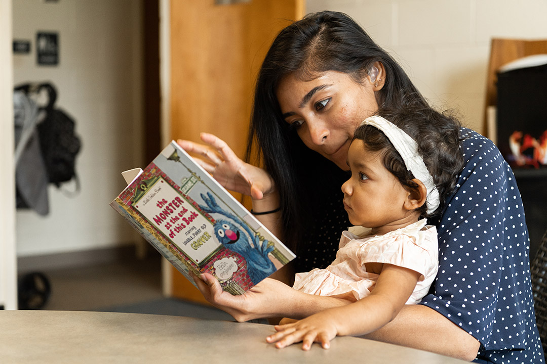 mother and child reading a Sesame Street book.
