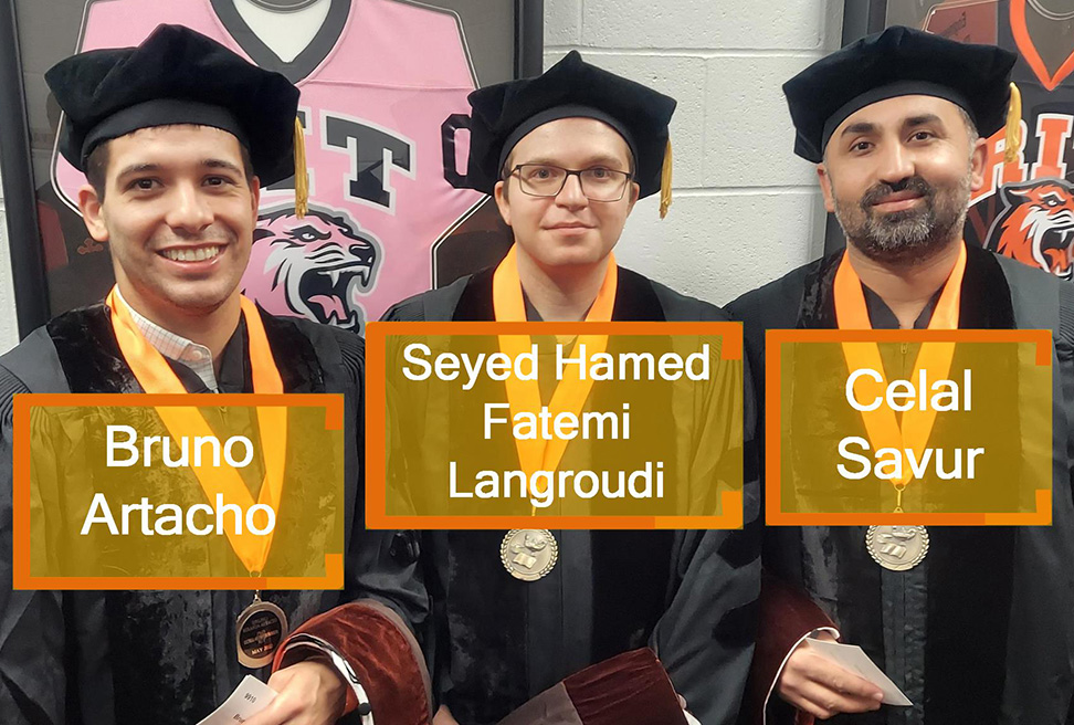 Three Ph.D. graduates wearing regalia.