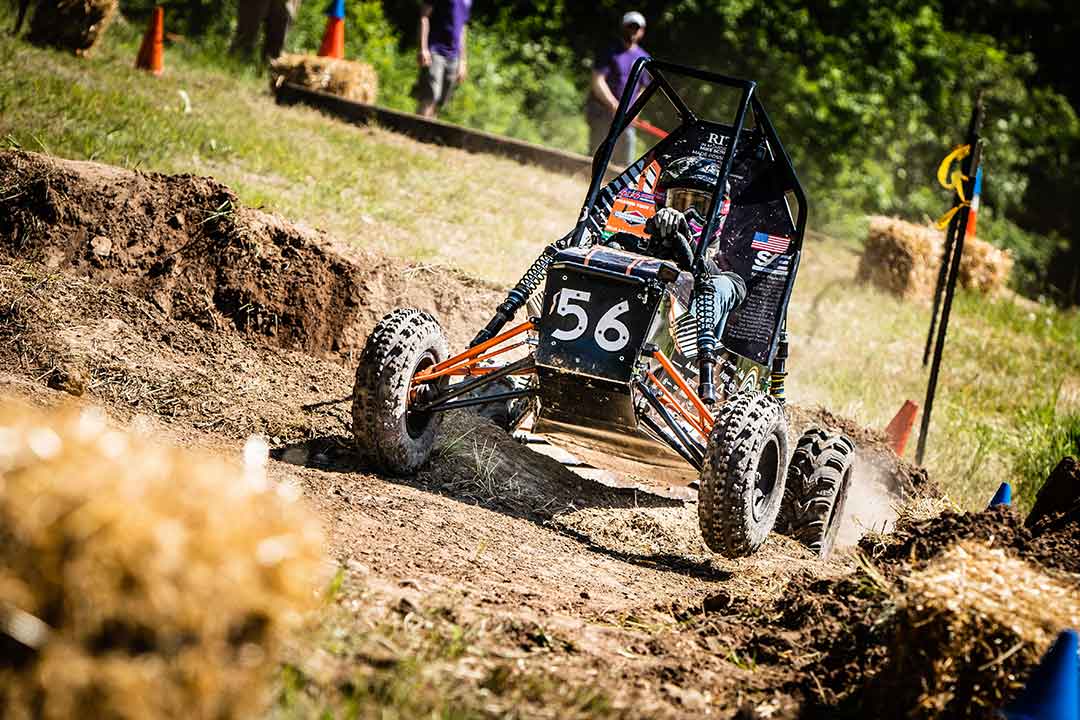 student driving Baja car on a course.