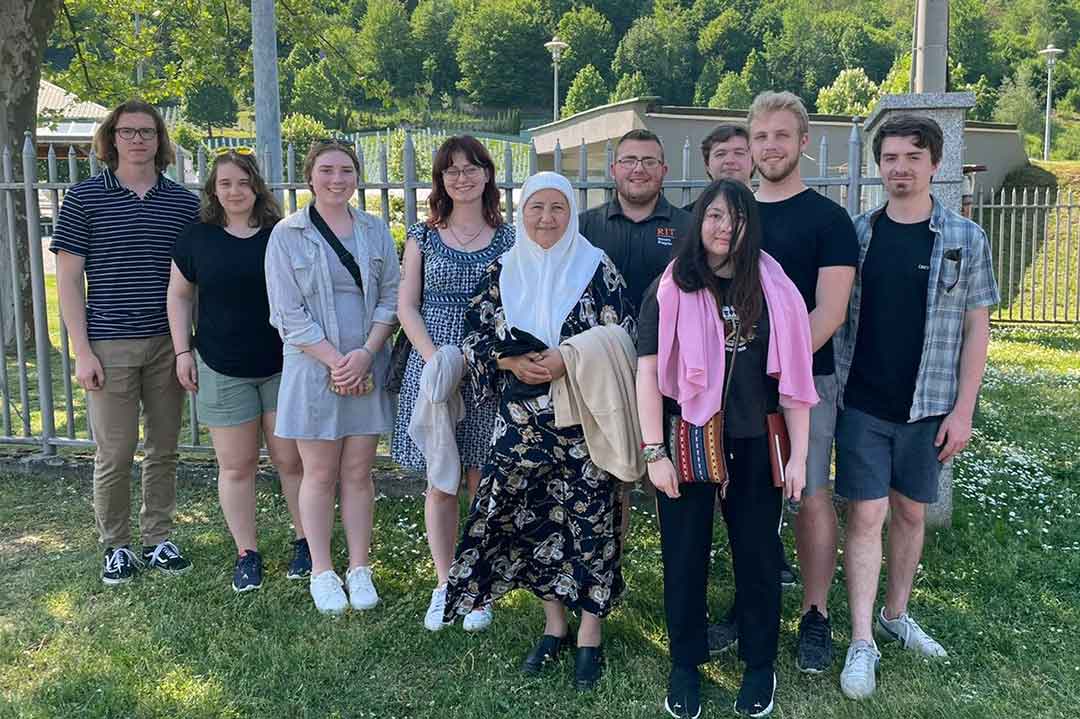 ten people standing outside posing for a photo.