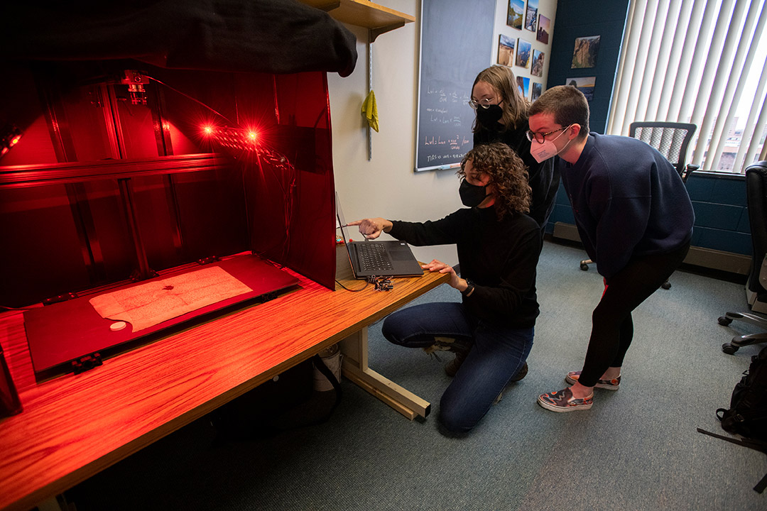 students looking at document under red lights.