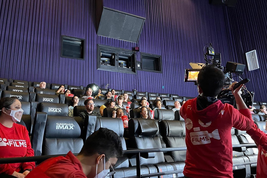 student crew filming a movie scene in a movie theater.