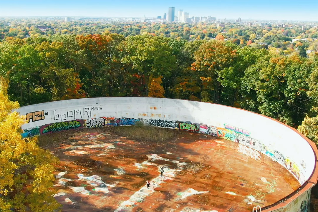 movie scene with the Rochester skyline in the background and two people on top of a water tower.