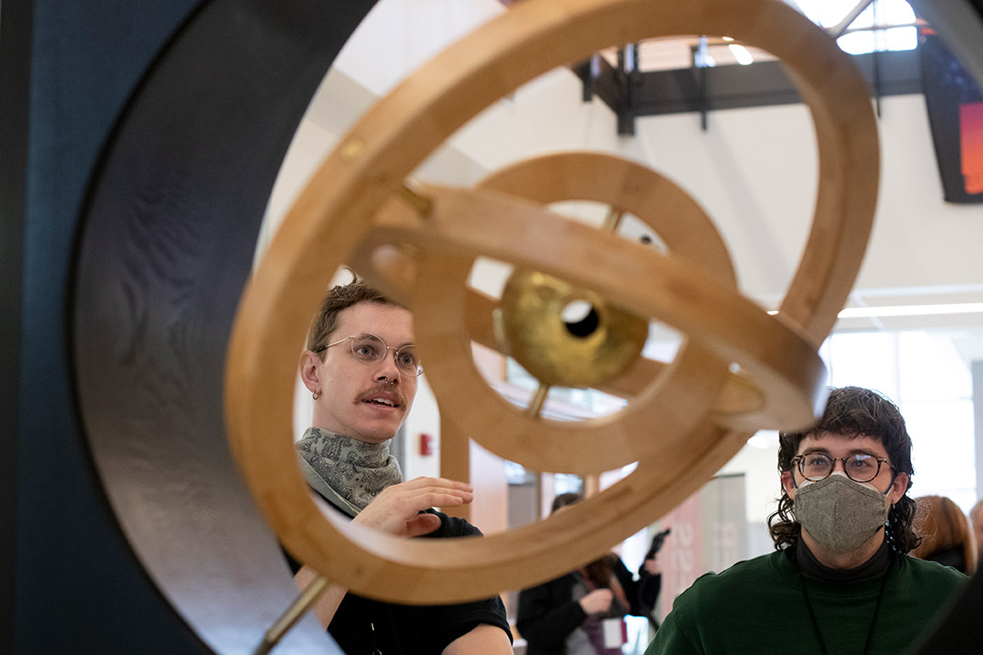 two people looking at a sculpture with three concentric circles.