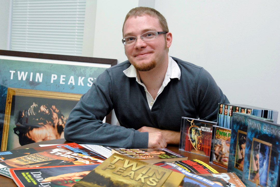Jared Lyon posing with "Twin Peaks" poster and merchandise.