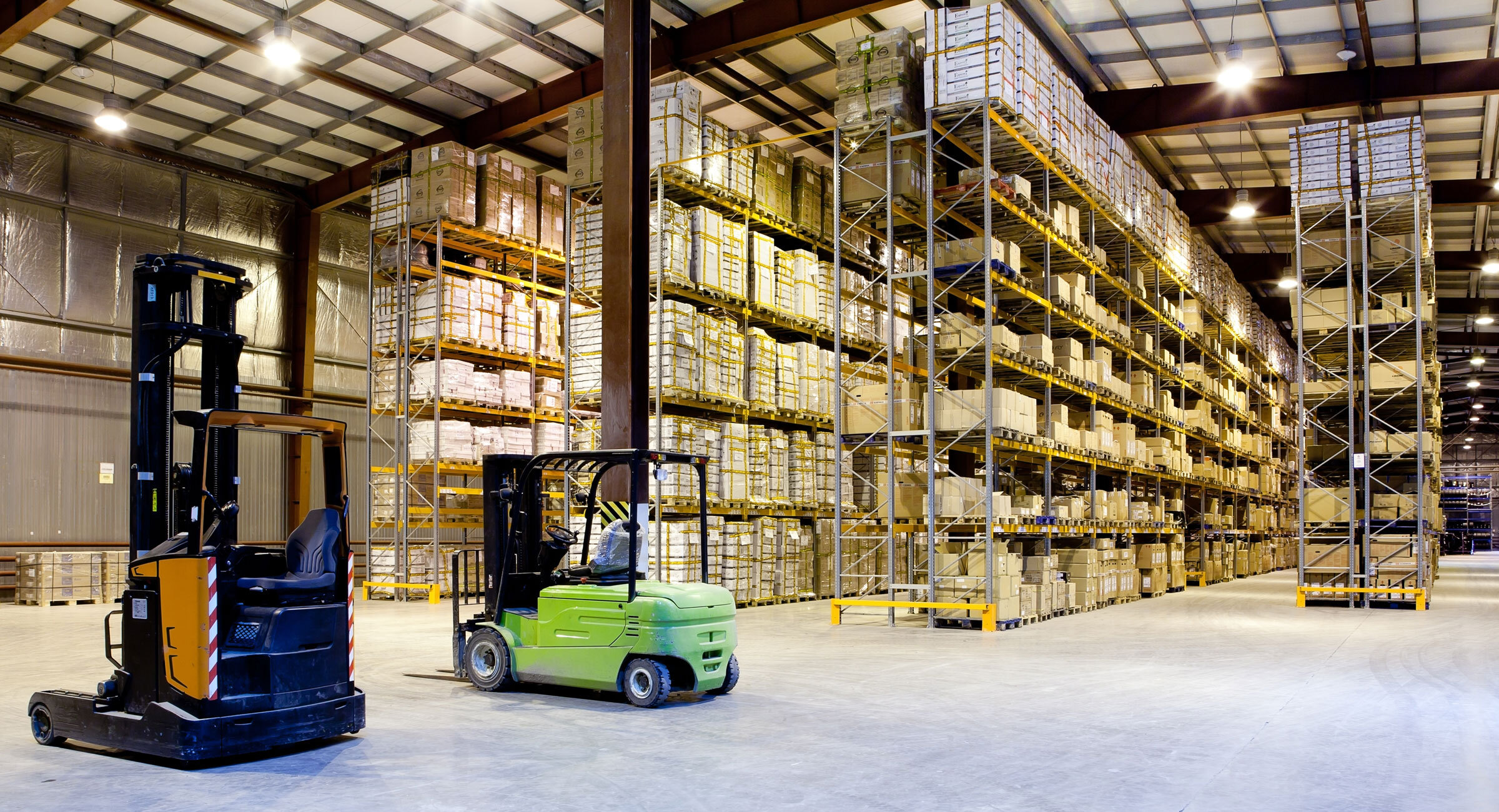 Forklifts are parked in a large warehouse facility. 