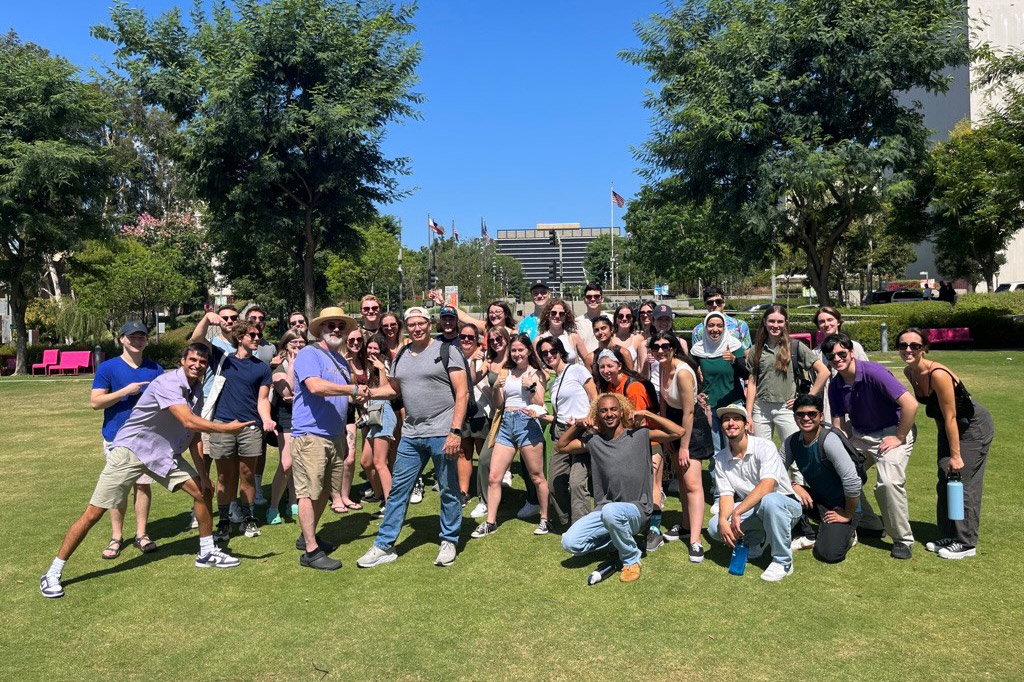 group of students and professors posing on a lawn.
