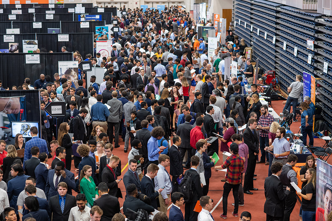 crowd of students in a field house for a job fair.