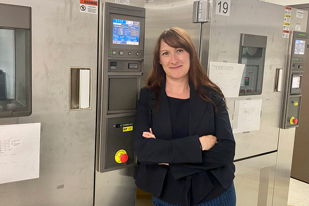 person standing in front of machinery that looks like a refrigerator. 