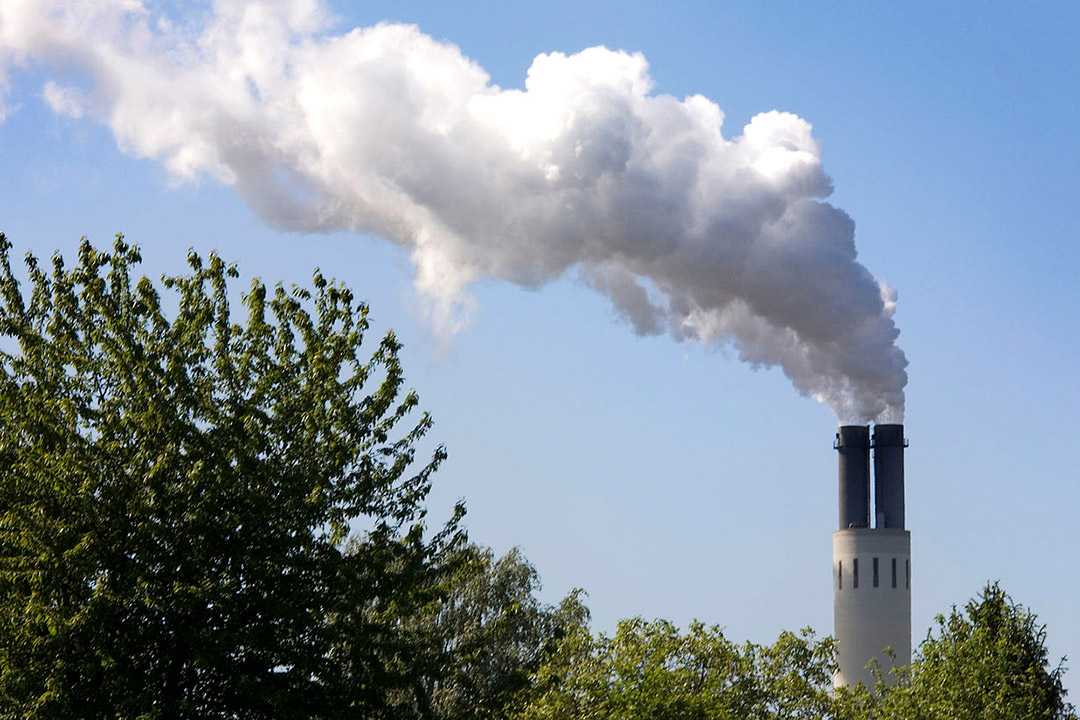 a smokestack from a building emitting exhaust.