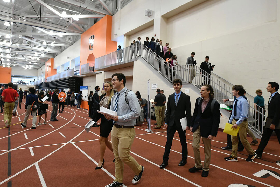 students walking into a field house for a career fair.