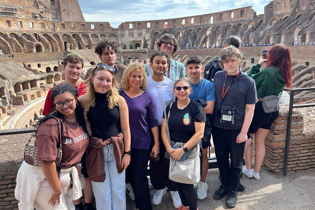 high school students posing in front of the Colosseum in Rome.