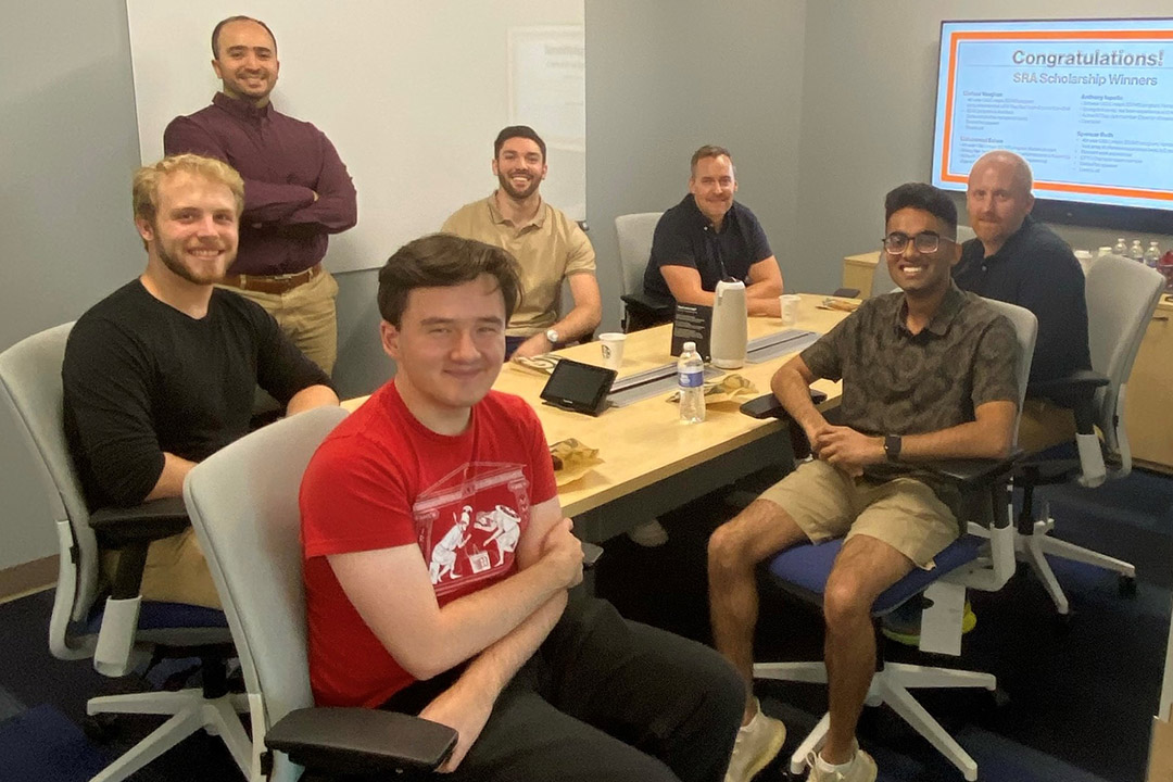 seven people sitting around a table.