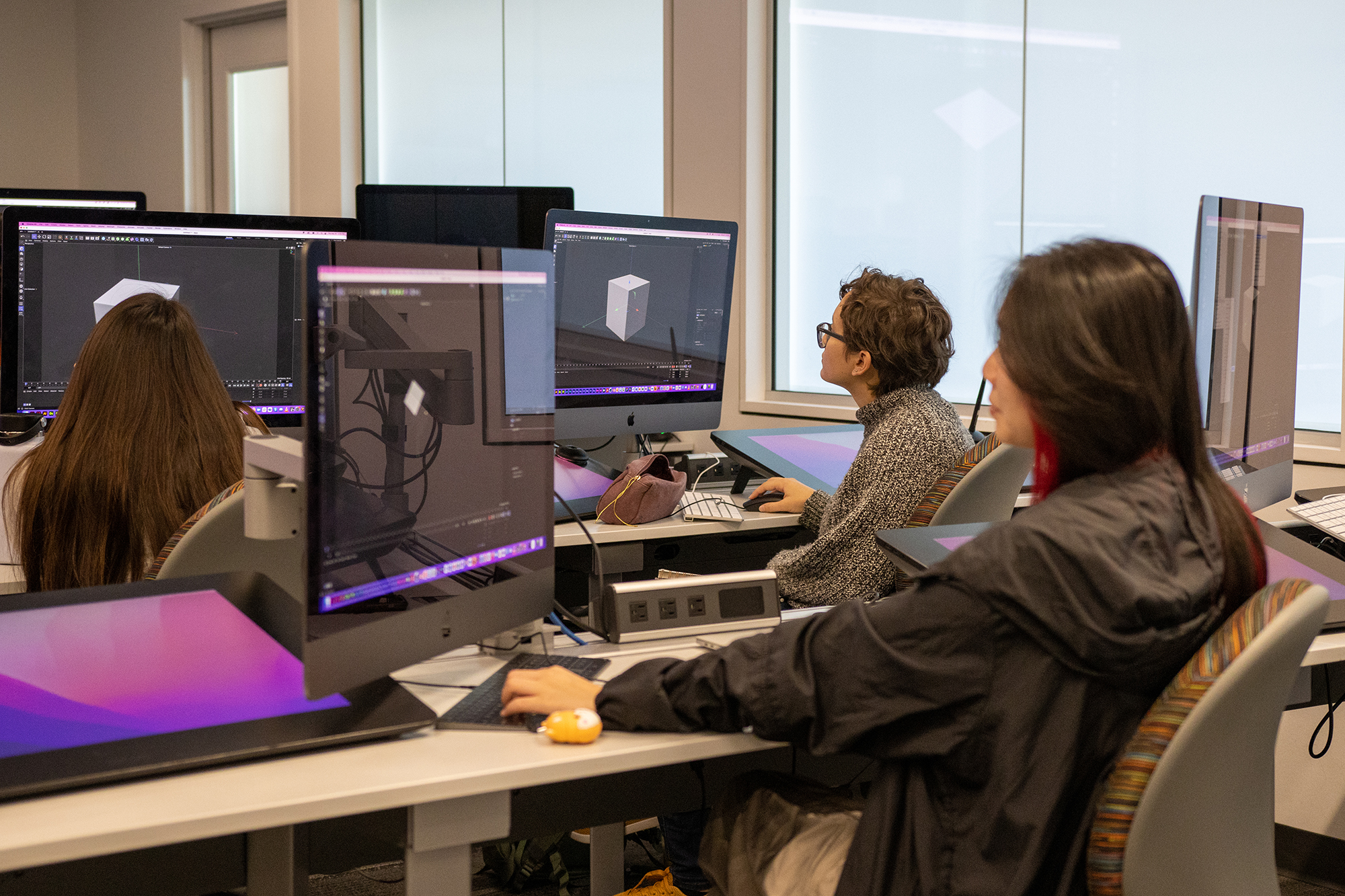 Students work at a computer in a lab.