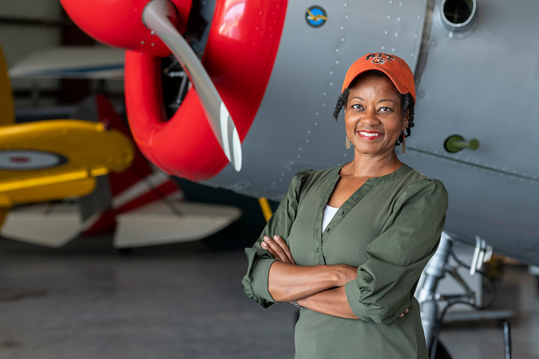 film director standing in front of a World War two era warplane.