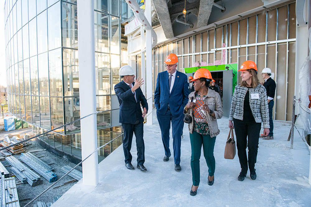 four people tour a building under construction.