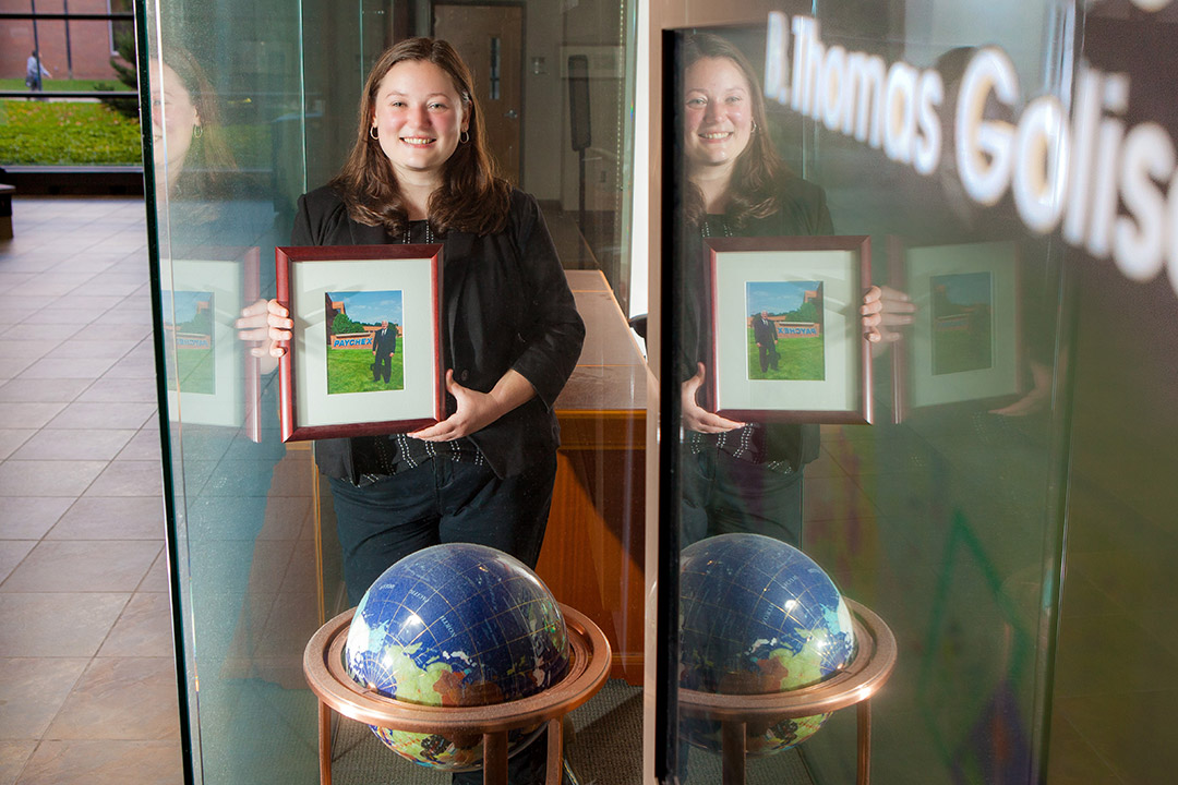 archivist standing in front of a window next to a globe.