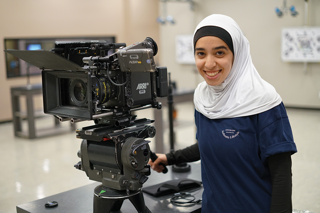 college student operating a movie camera.