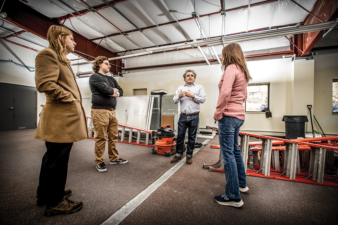 four researchers standing in a room under construction.