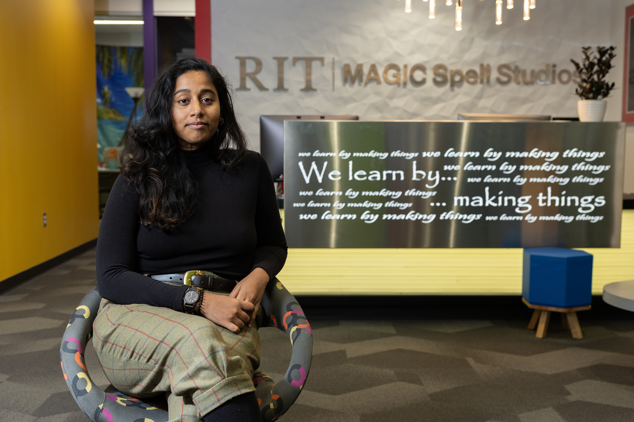 Tish Kahn sits in a chair for a portrait in RIT's MAGIC Spell Studios.