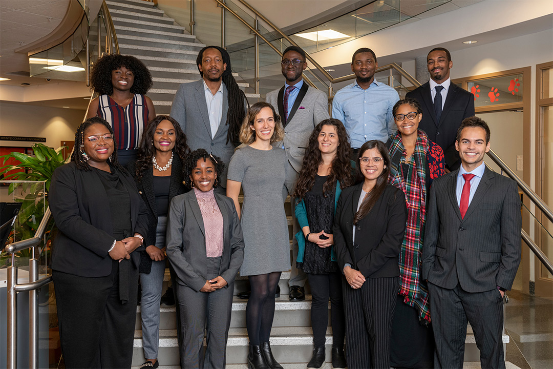 13 scholars posing on stairwell.