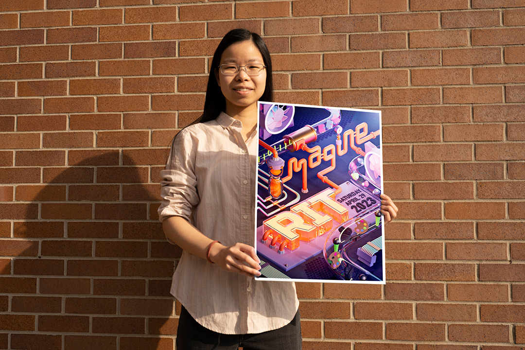 college student holding a poster for Imagine RIT.