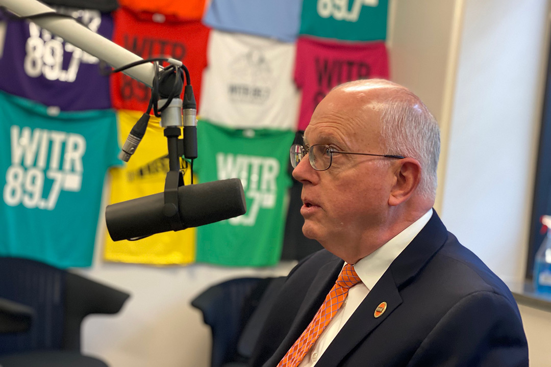 RIT President Munson talking in a radio station microphone.