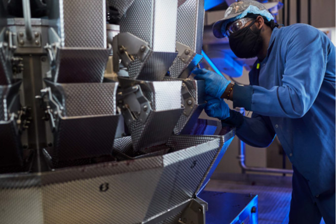 person working on manufacturing equipment.