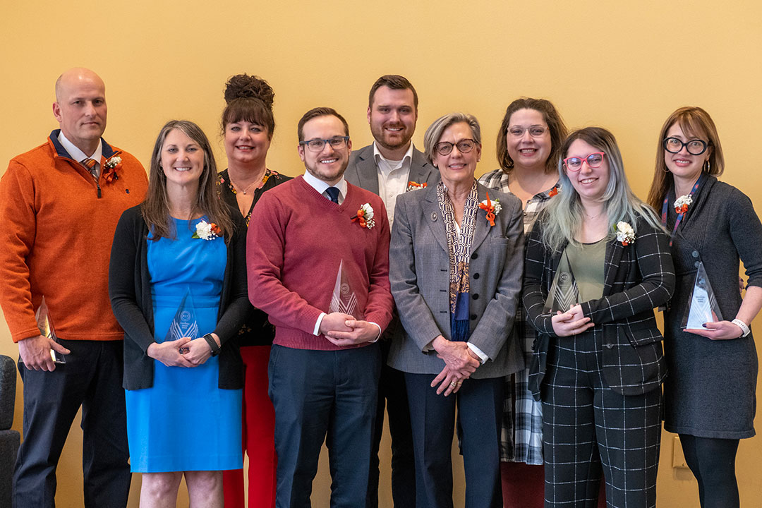 nine staff members pose for a group photo.