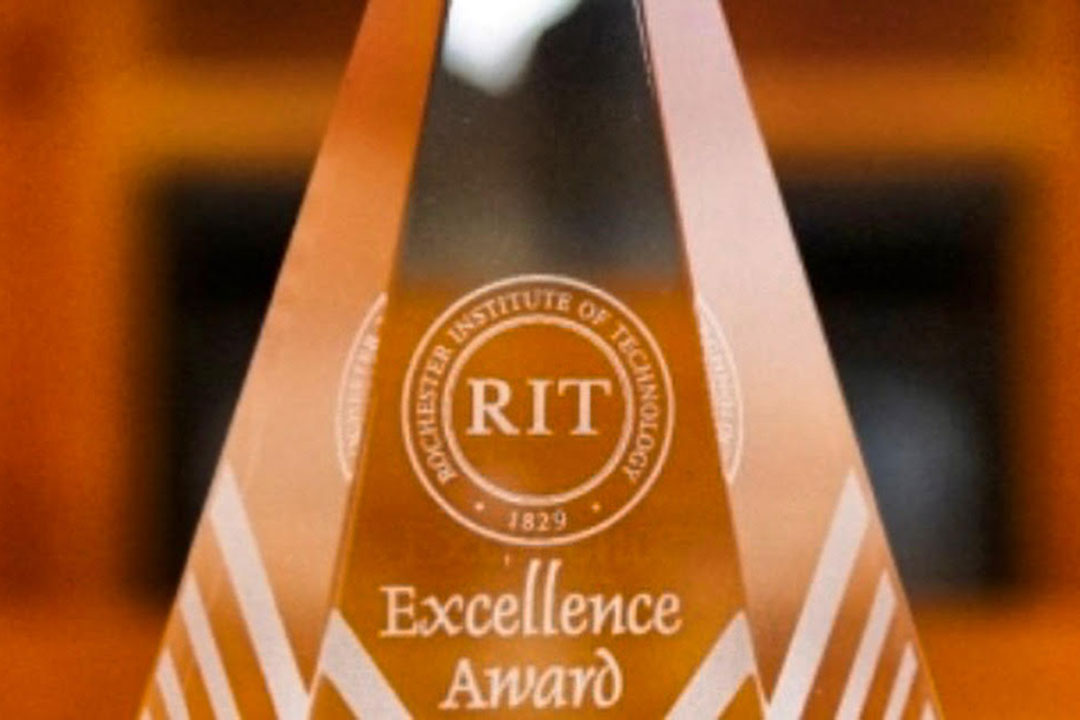 Image of an excellence award made of glass and engraved with award highlights