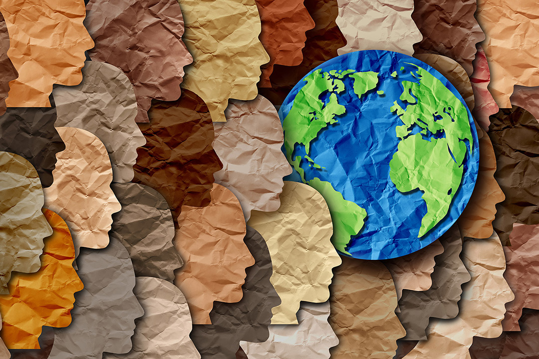 collage of paper profiles of different skin tones facing the Earth.