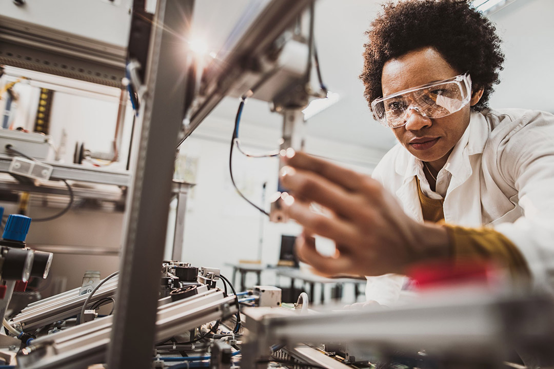 researcher connecting wiring to machinery.