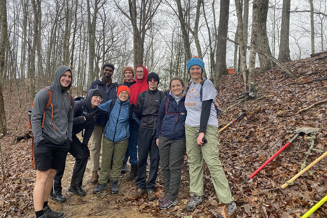 Group of RIT students in the woods pose for photo.