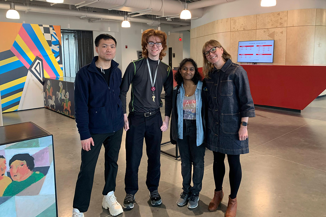 four college students posing for a photo at a conference.