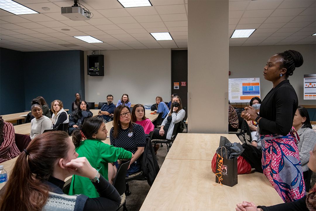 Person talking to group of students in a classroom.