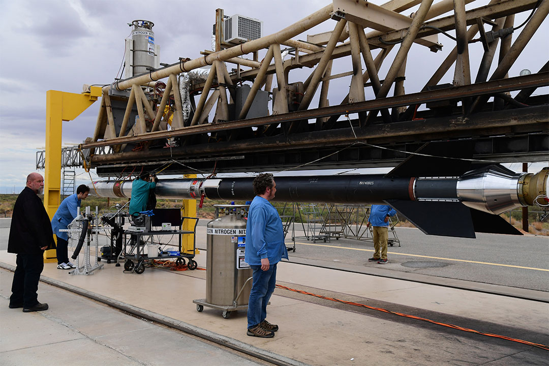 scientists checking on a rocket at a missile range.