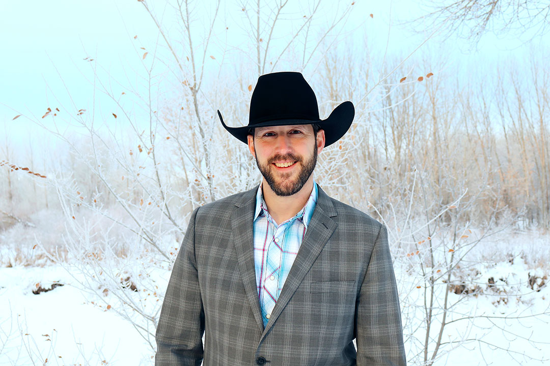 Portrait of a person outside wearing a cowboy hat.