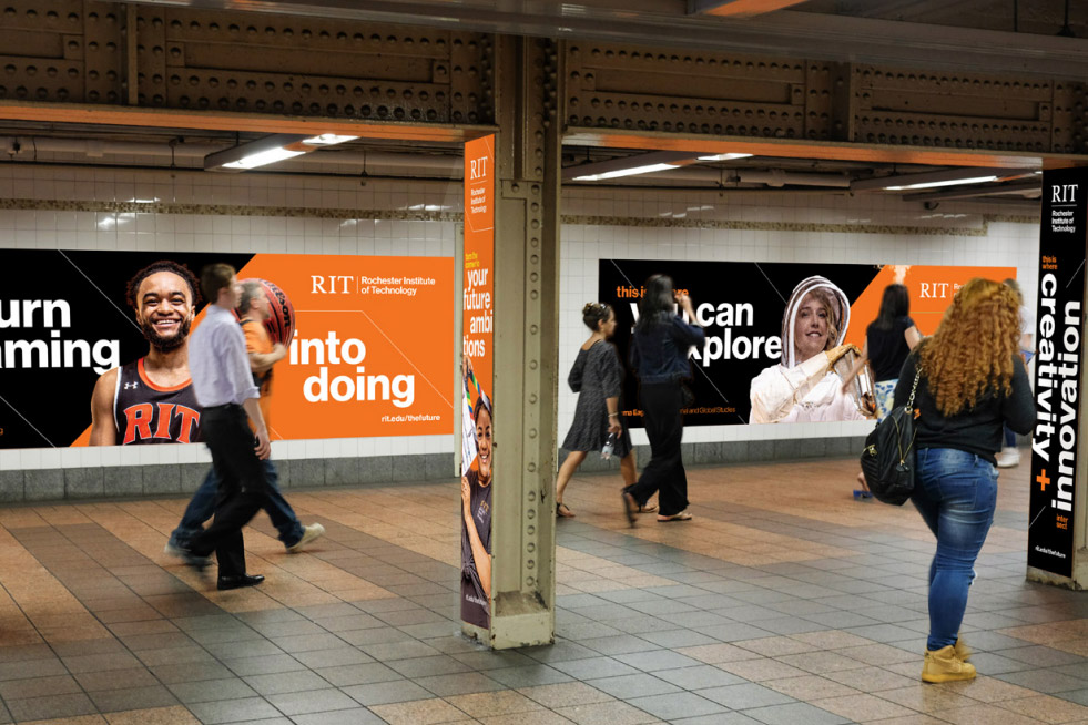 people walking through a subway station with ads for R I T on the walls.