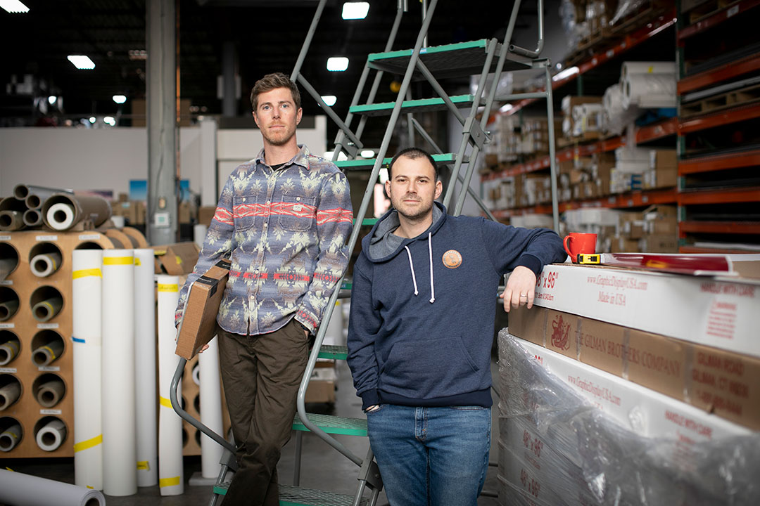 two people standing in a warehouse for photo.