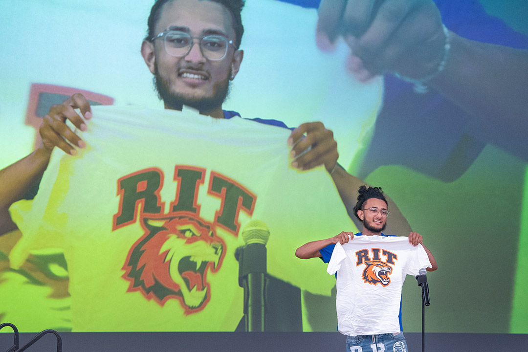 high school student holding up an R I T T shirt.