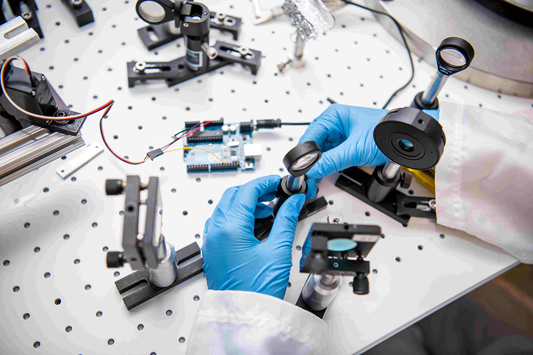 researcher setting up a series of lenses and other equipment. 