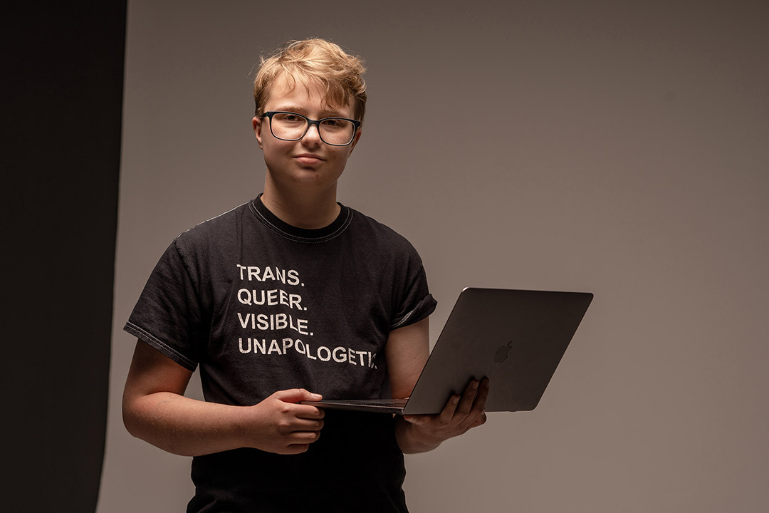 college student holding a laptop computer.