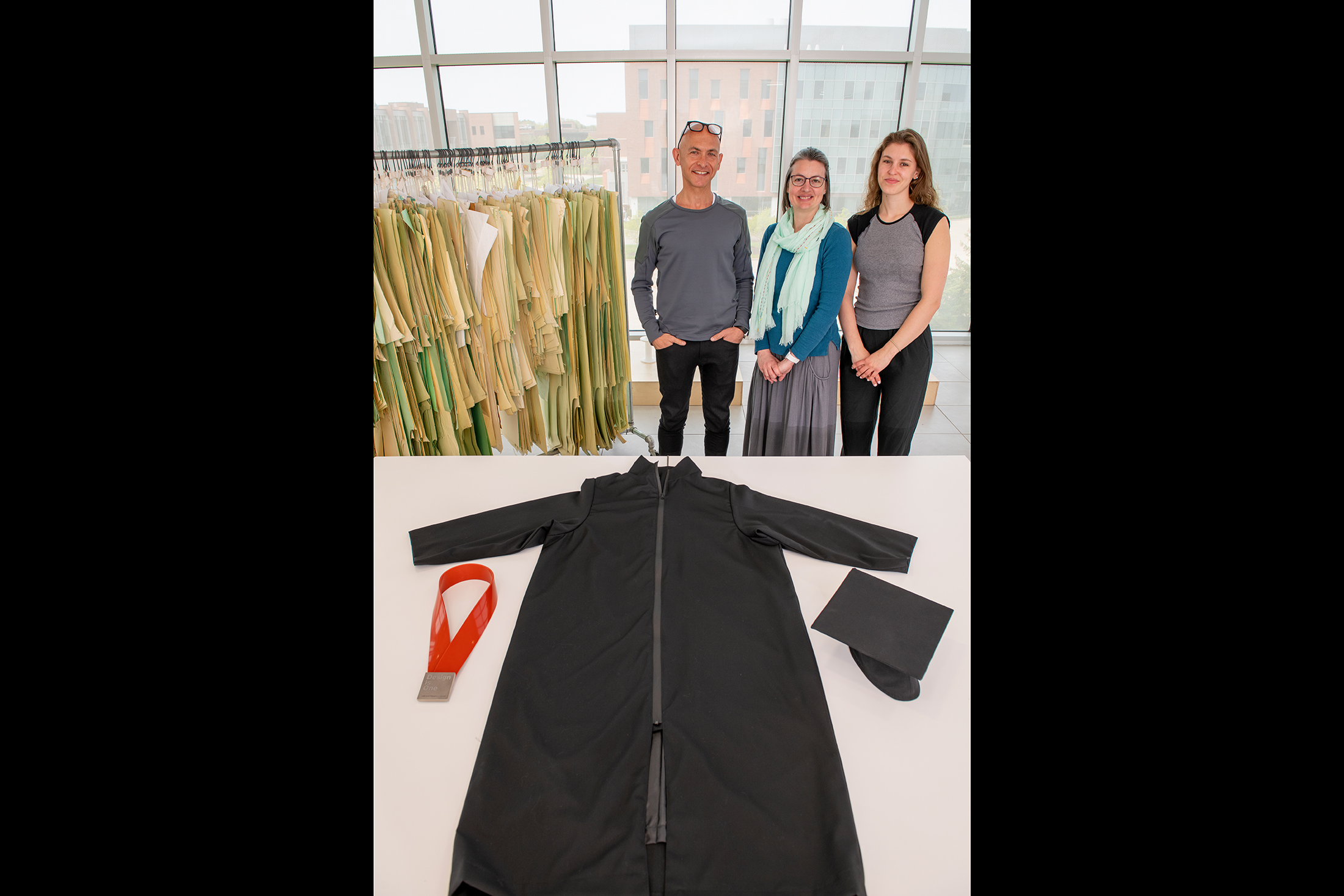 Josh Owen, Melissa Dawson and Clare Maxwell pose in front of Vignelli fabric, while a second photo of regalia using Vignelli fabric sits below.